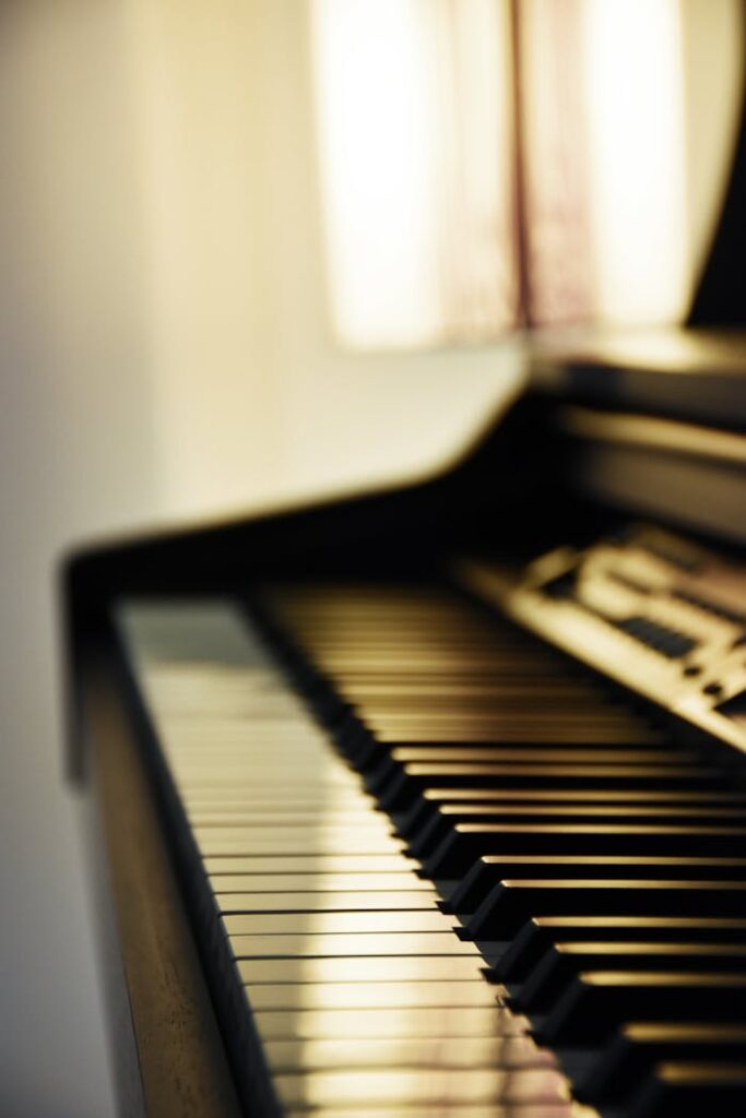 pexels-photo-3825738 A close-up of grand piano keys bathed in soft light, showcasing elegance.