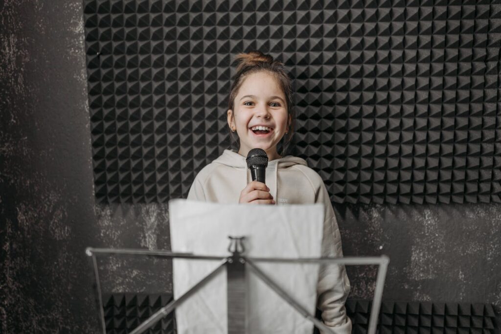 pexels-photo-7521305 Young girl singing into a microphone during a music lesson in a studio.